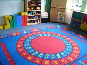 Playroom with an alphabet carpet and toy shelves