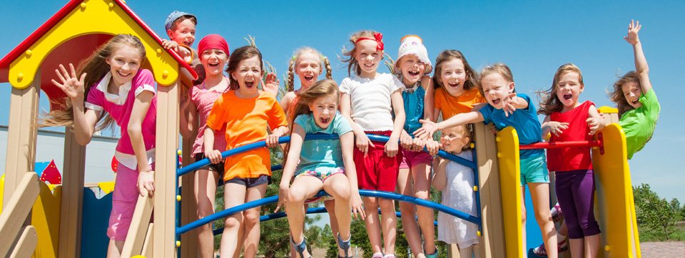 A group of children waving from a playground